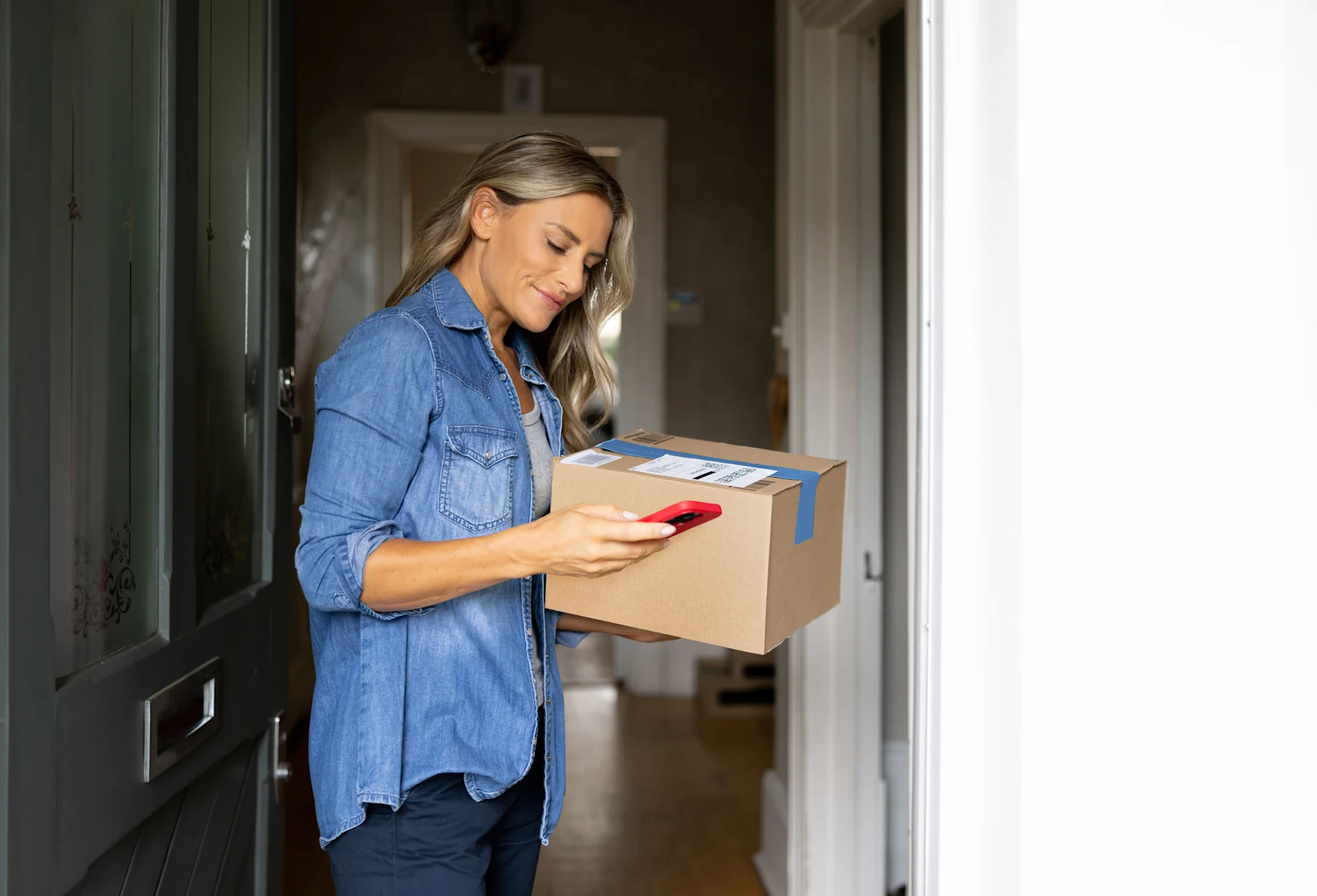 Woman holding parcel while on mobile phone