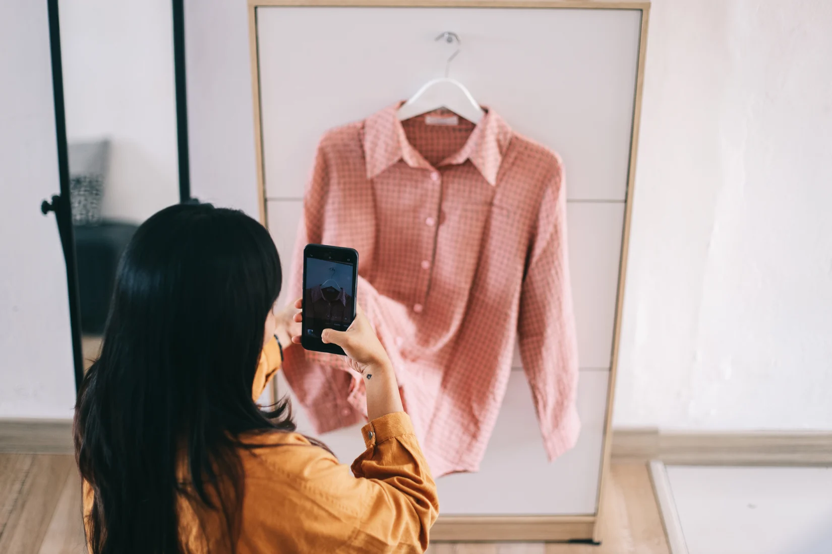 Woman taking photo of shirt for Instagram marketplace