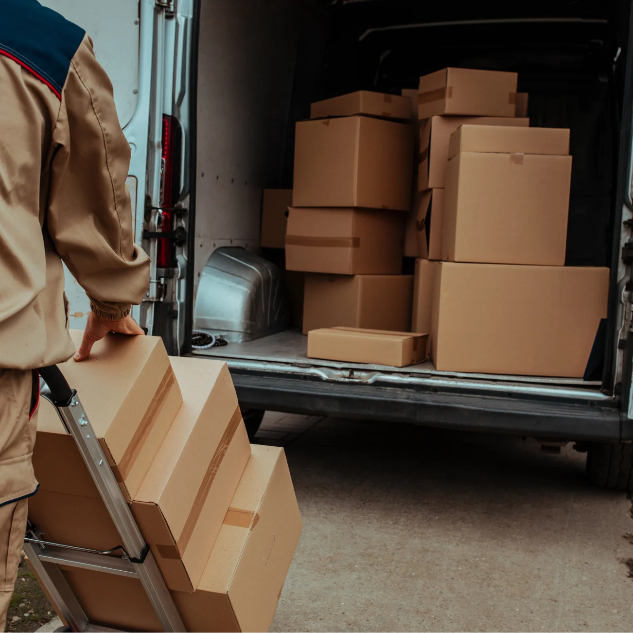 Deliveryman loading large parcels into van