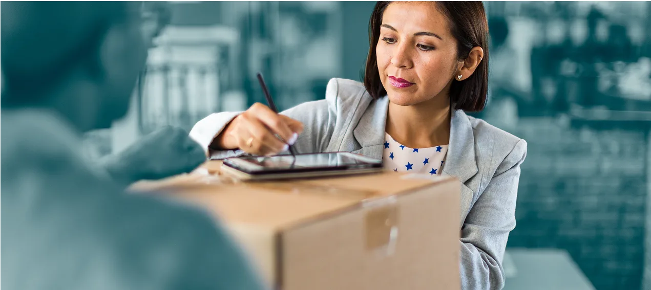 Woman signing for parcel at store