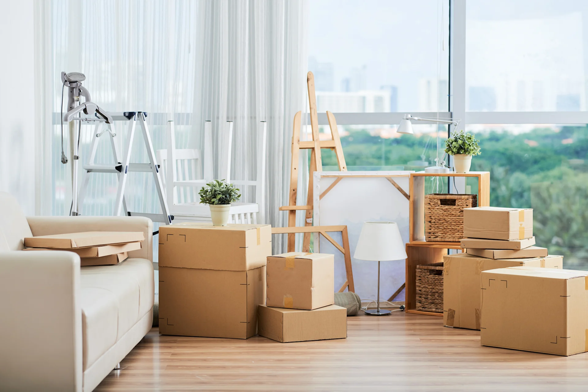 Easel and packaging boxes sat on the floor of a brightly lit room with large windows.