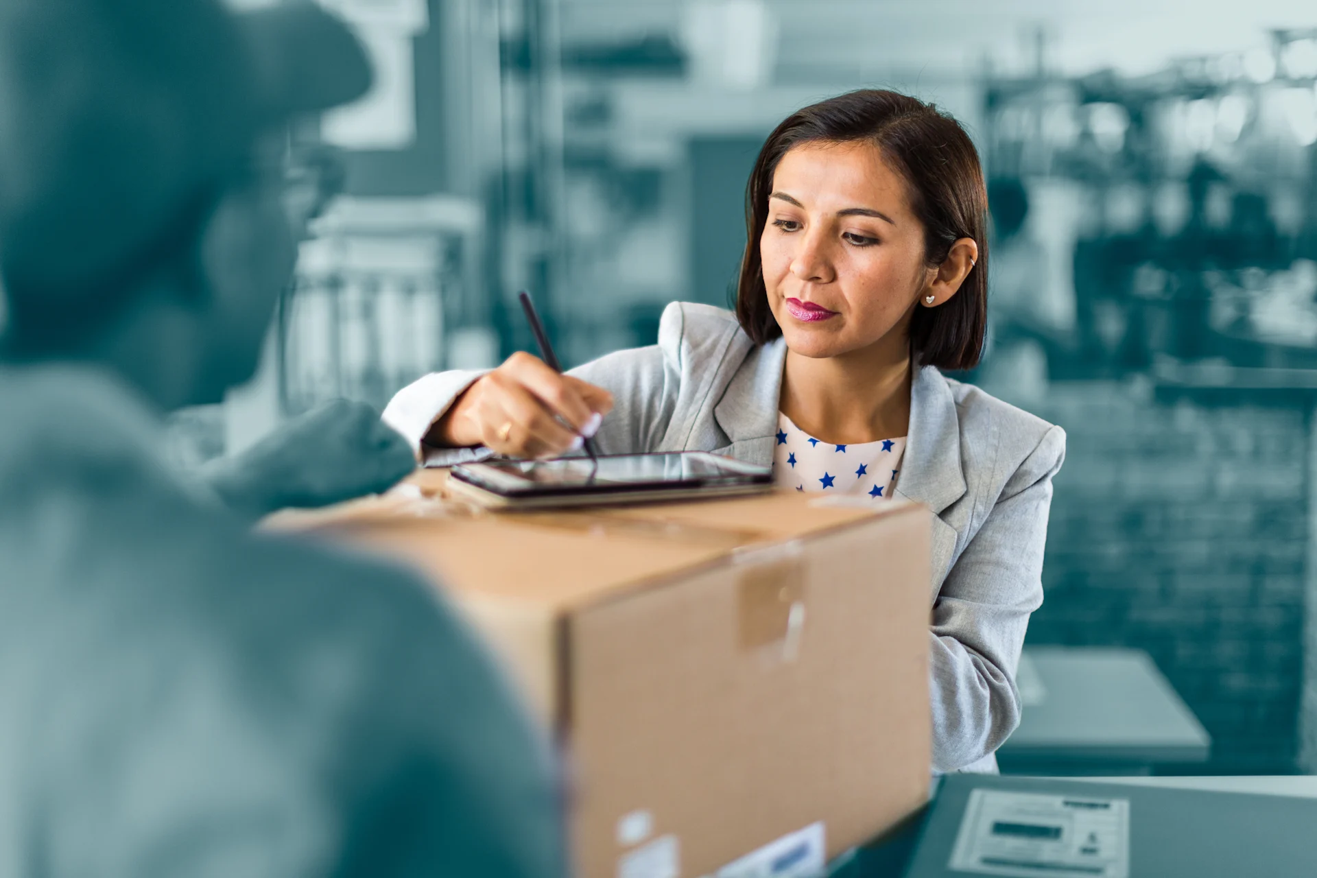 Woman signing for parcel at storefront