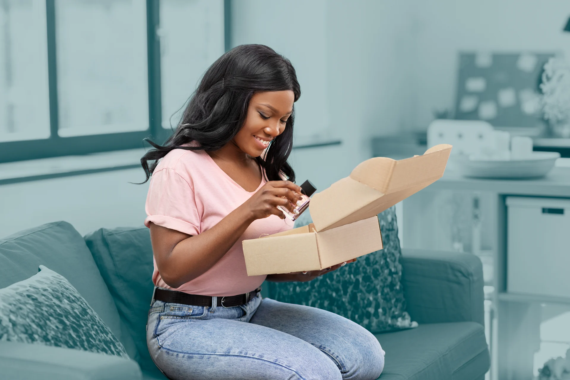 Vrouw opent pakketje op de bank thuis