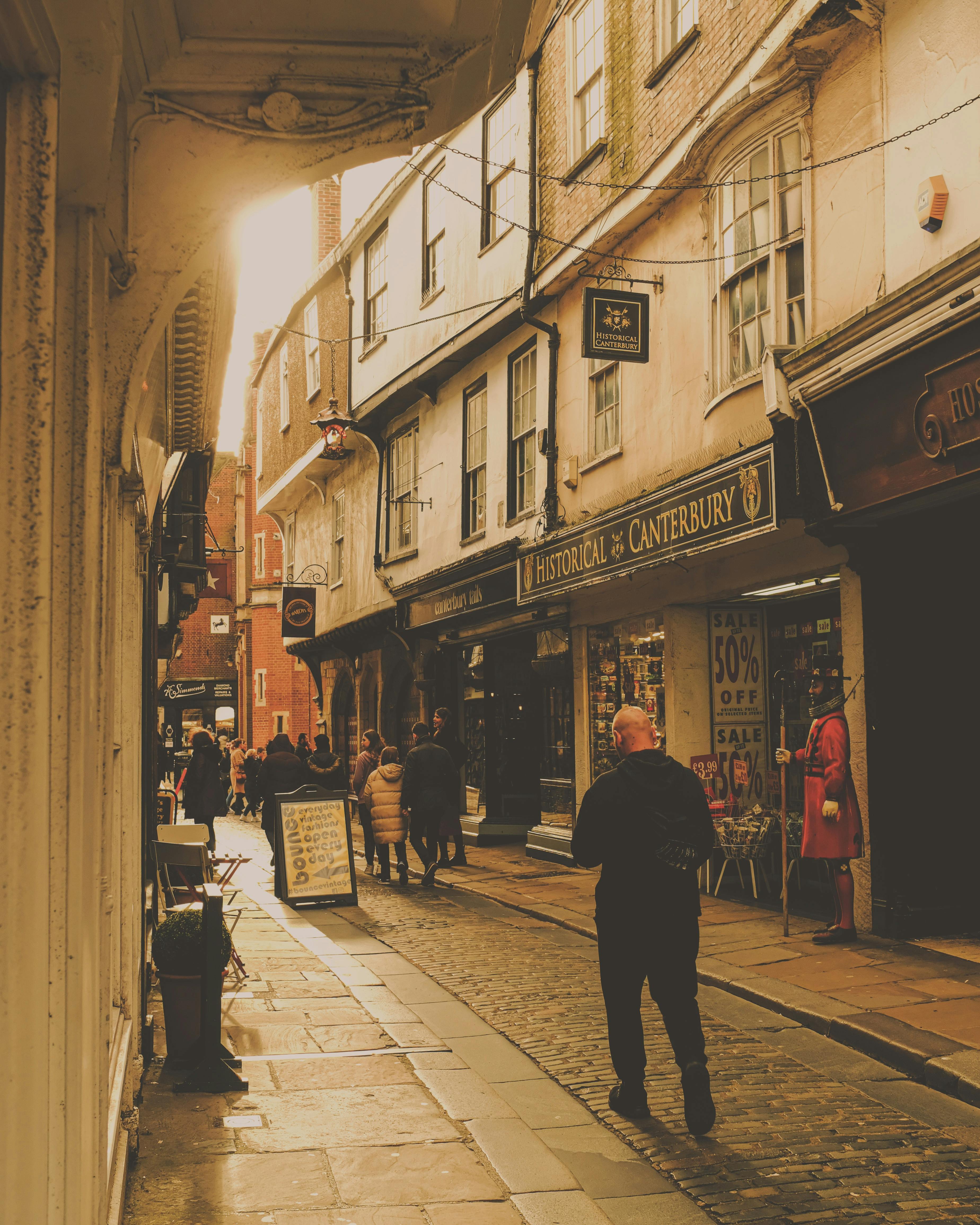 People Walking through an Old Town Shopping Street