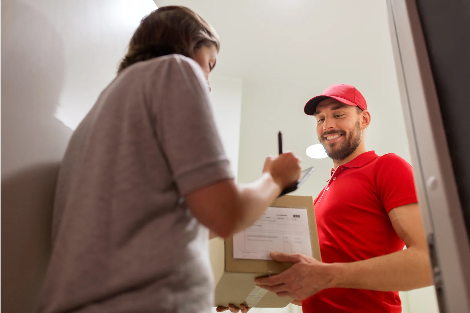 Smiling Parcelforce delivery man handing over parcels at door