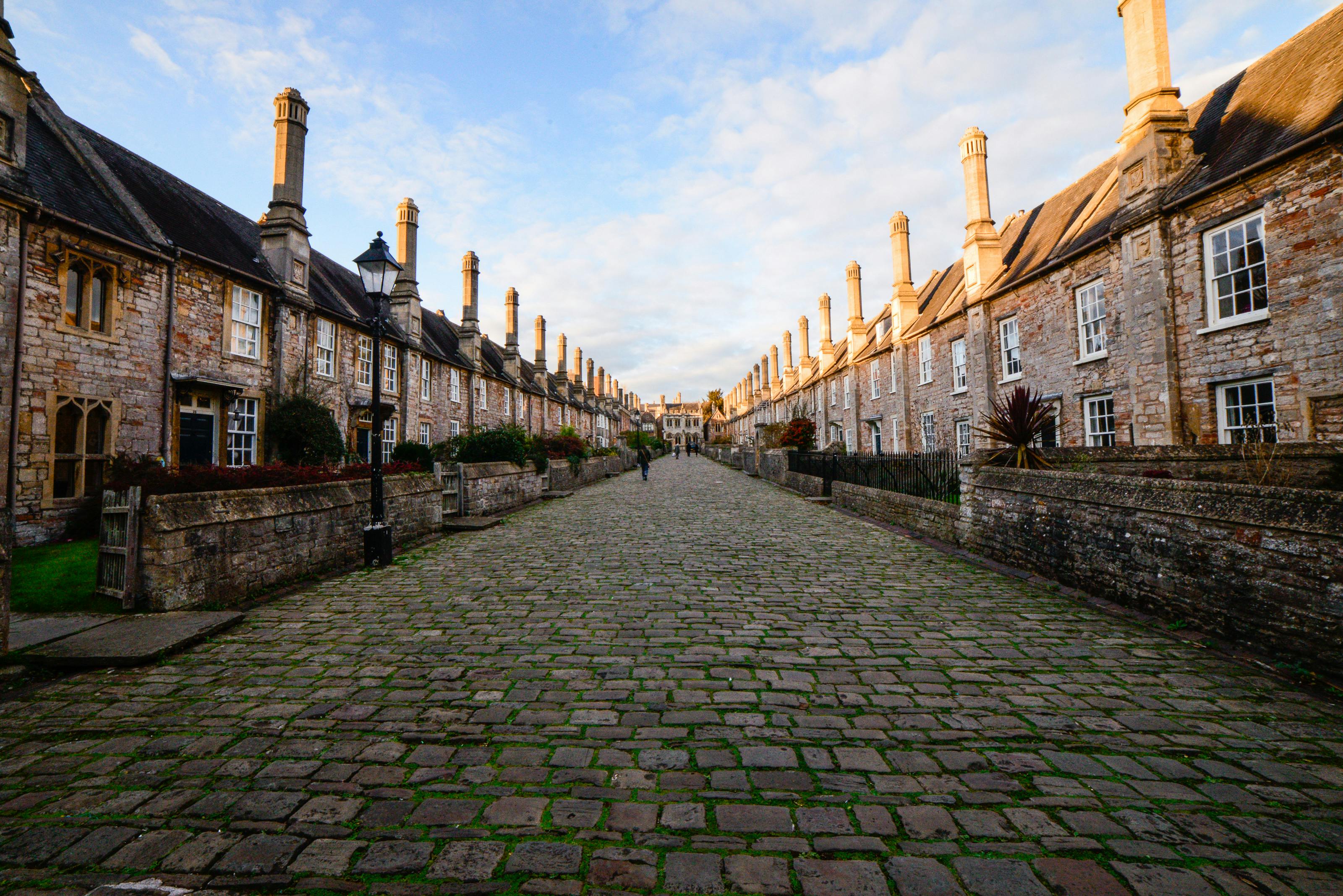 A narrow cobblestone street surrounded by brick houses