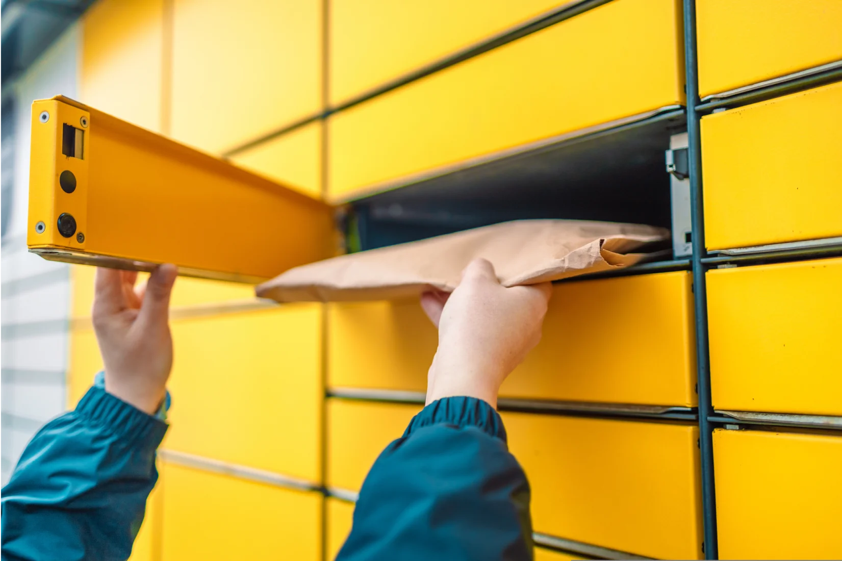 Close up on someone depositing parcel into yellow InPost locker