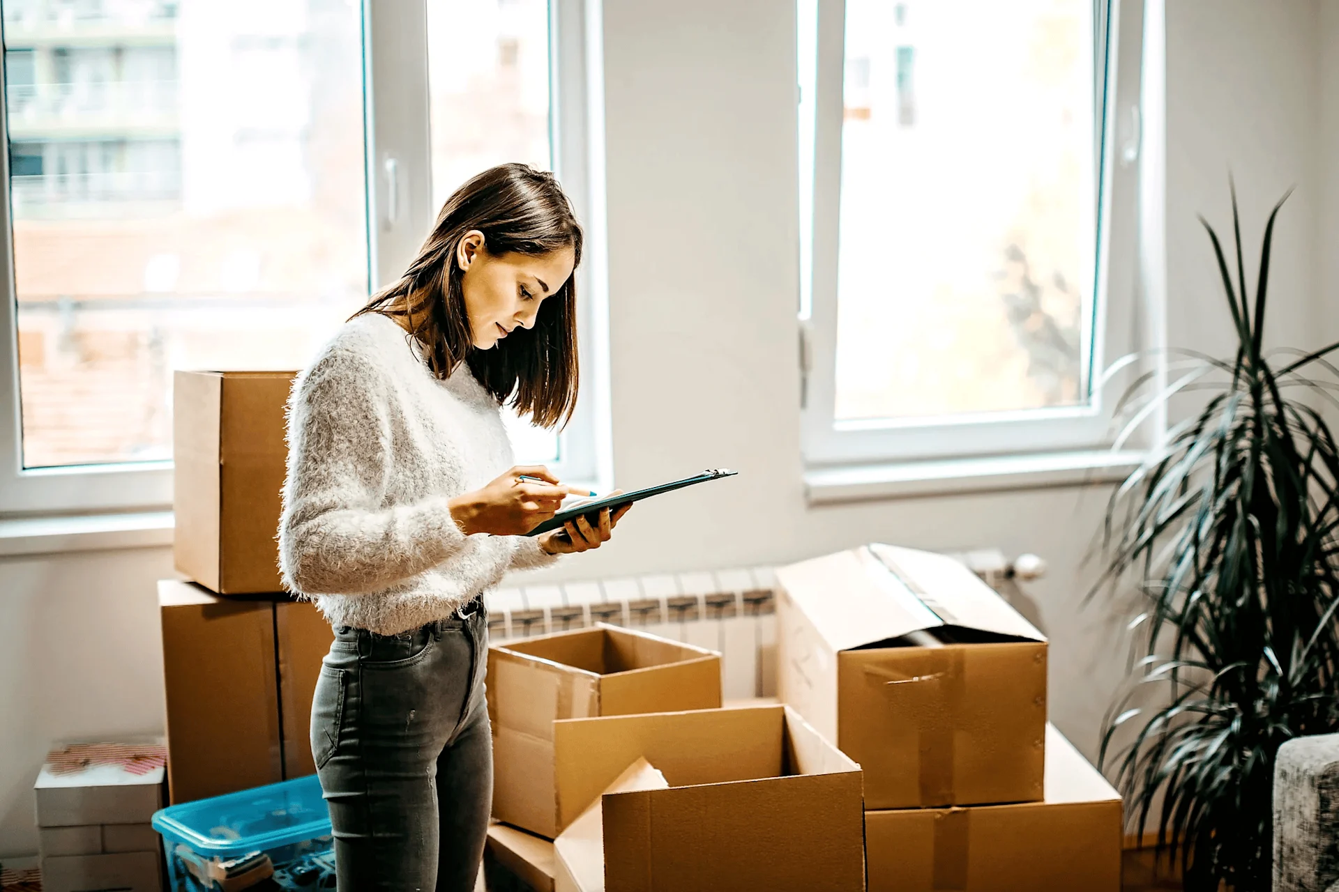 Woman looking at checklist while moving home