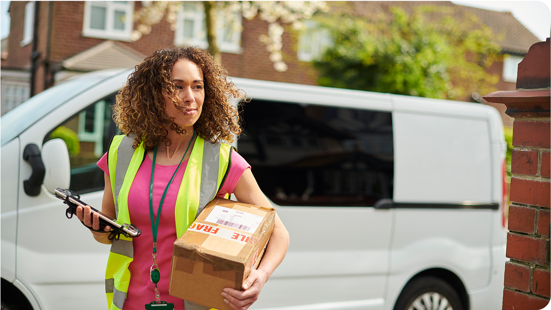 Parcel delivery woman approaching a house.