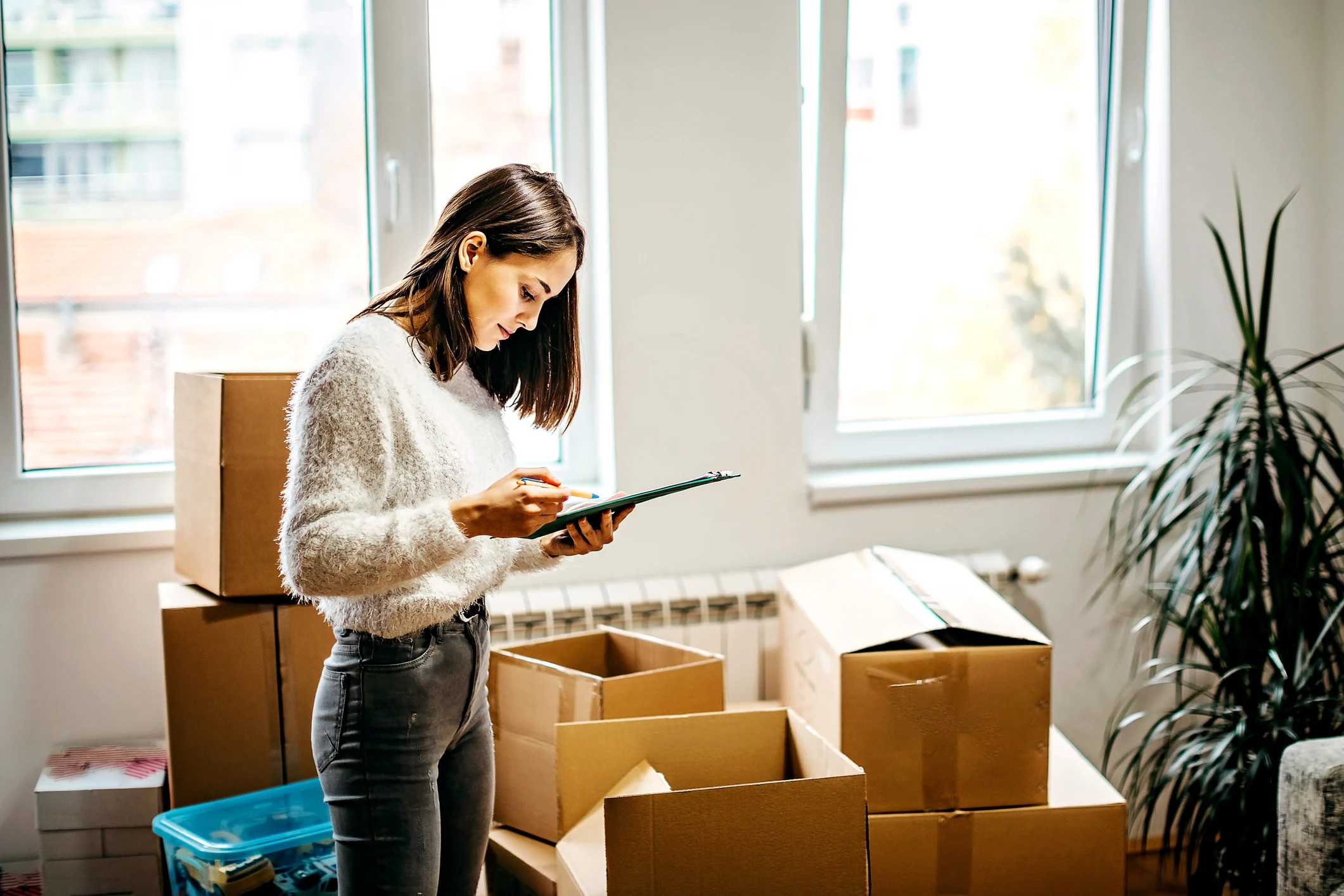 Woman with clipboard surrounded by boxes