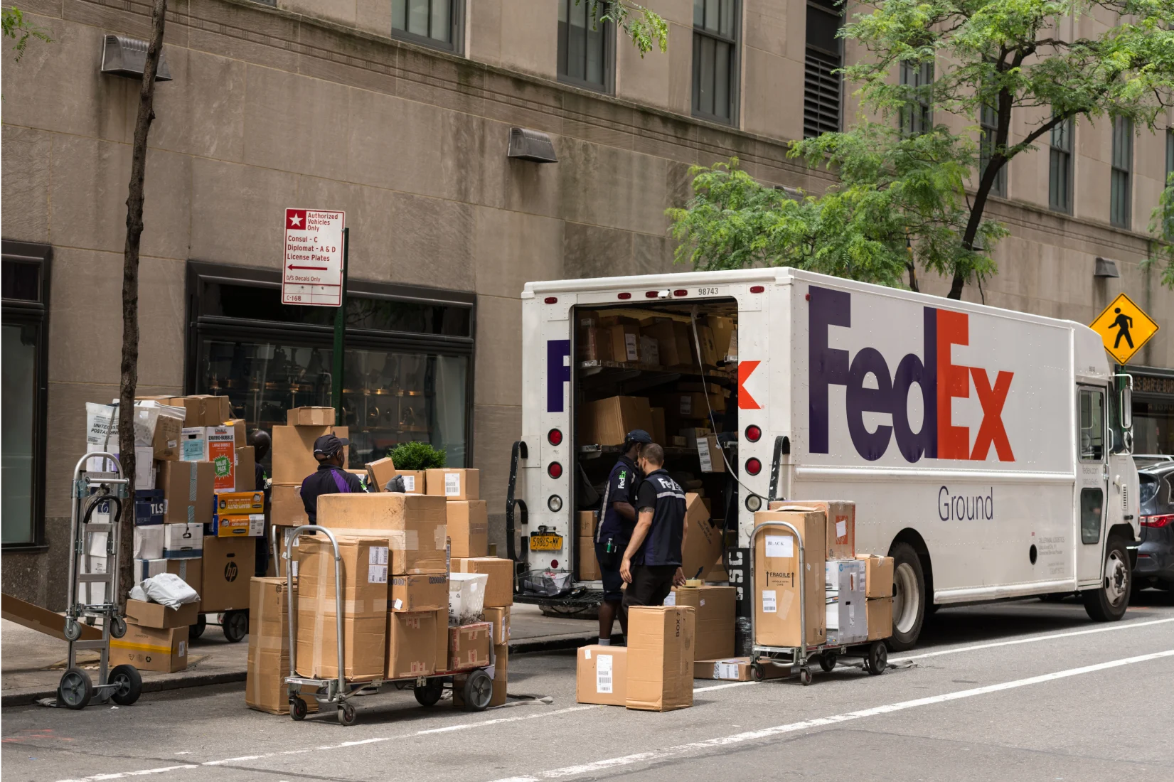 FedEx Express lorry in street with delivery man removing boxes from back