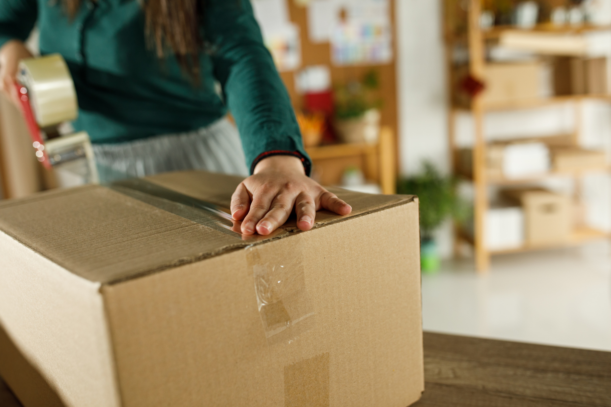 Person sealing parcel with tape