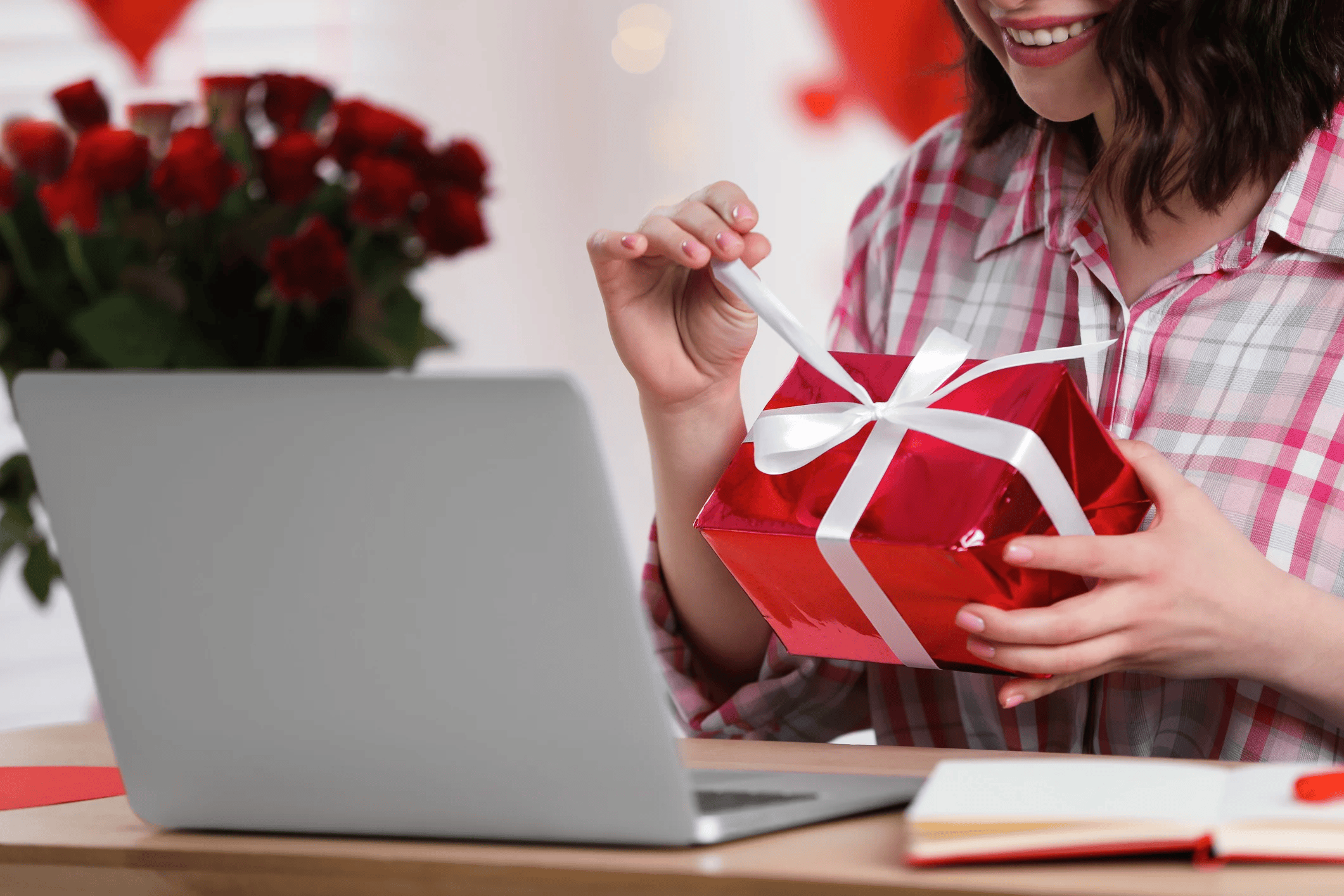 woman on laptop opening valentines gift
