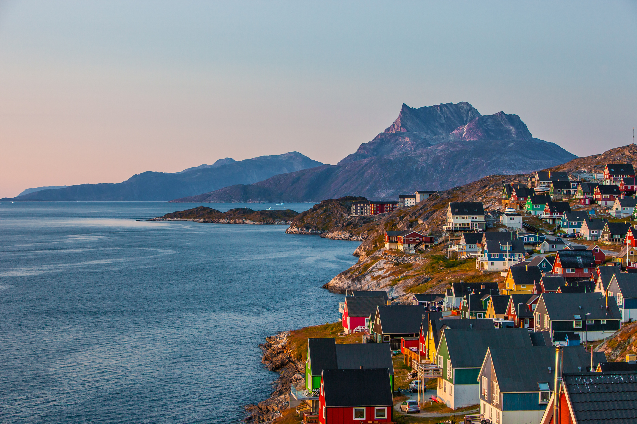 Colourful houses on the shore in Greenland, and a pink evening sky