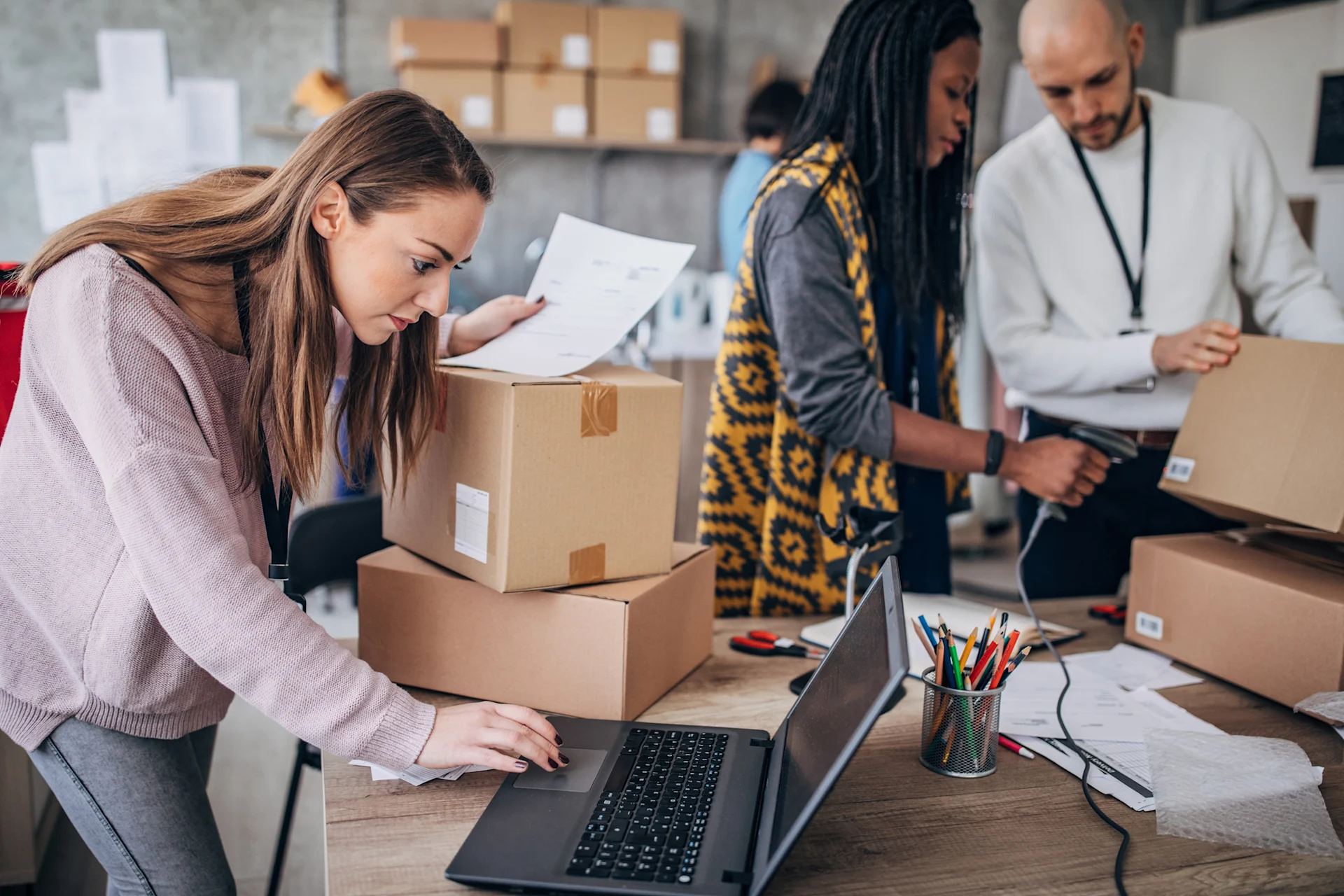 Person on laptop while holding parcel