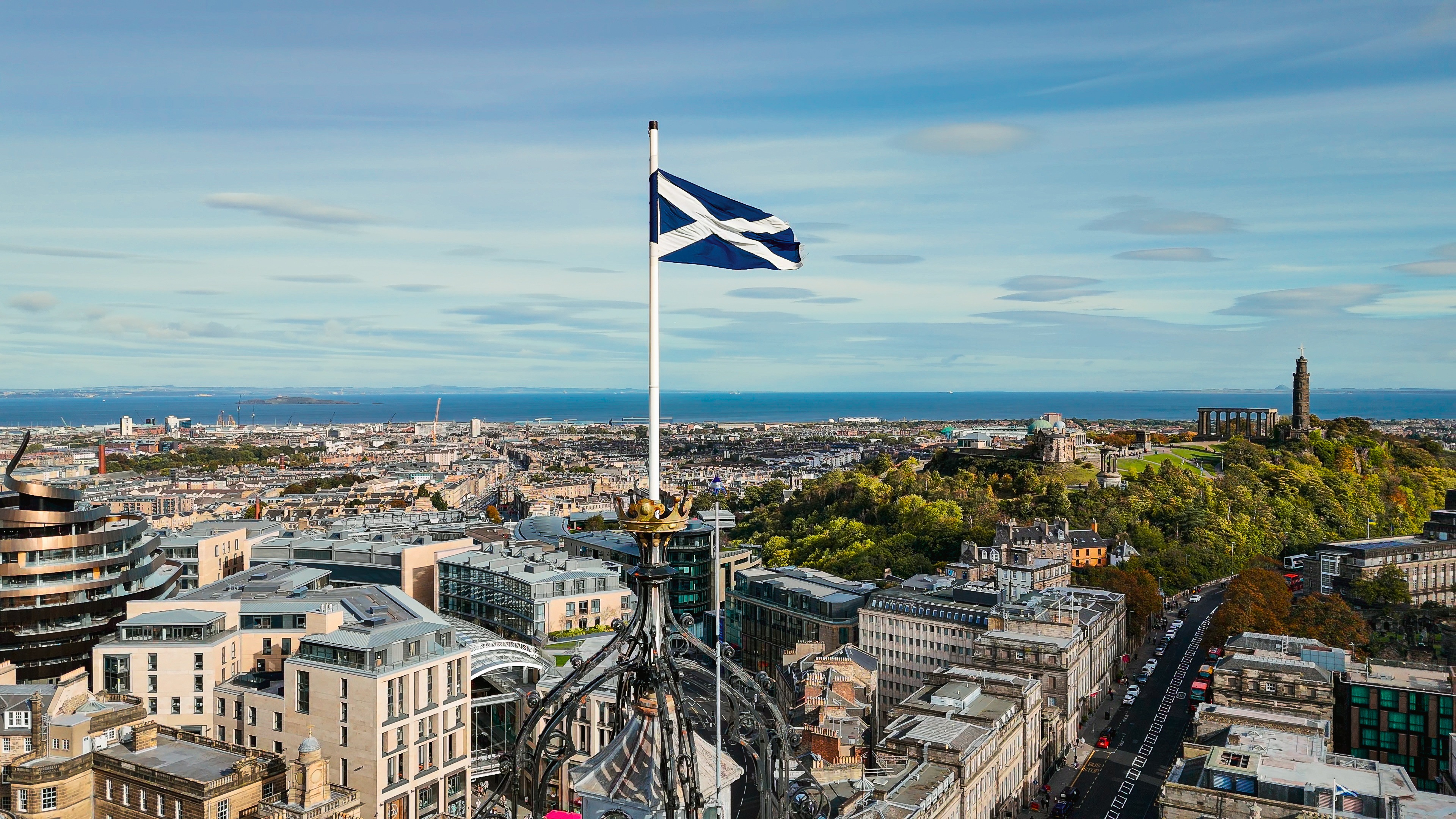 Scotland flag flown from a tall building looking across Edinburgh city centre 