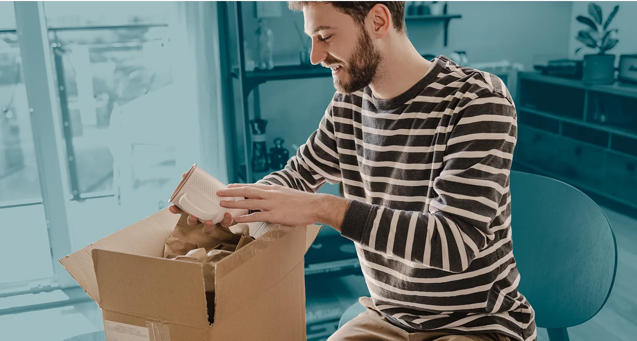 Man unboxing item from parcel at home