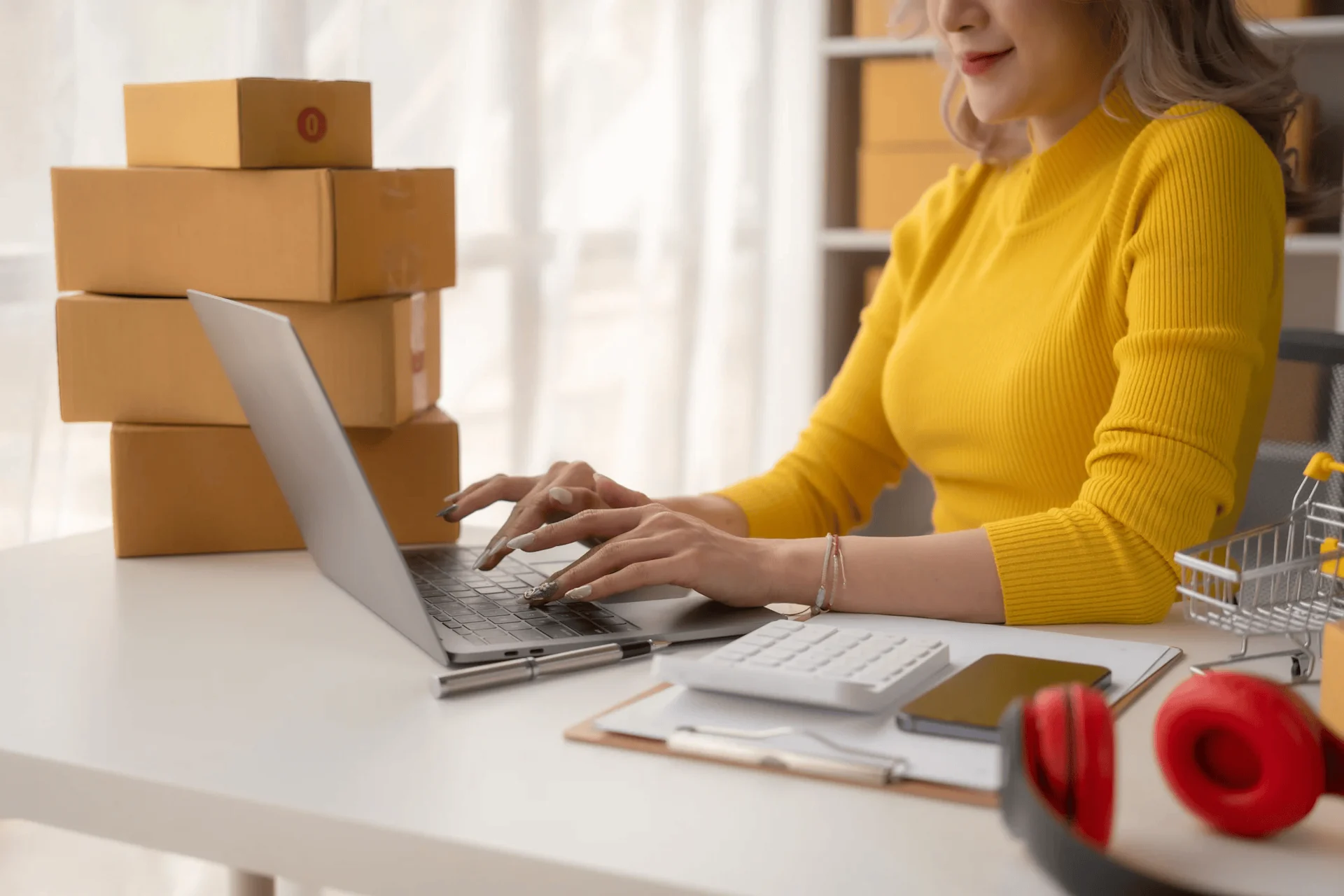 woman on laptop with parcels on desk