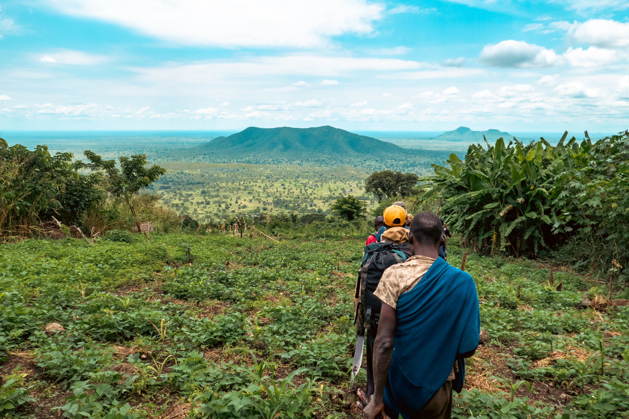 people walking across fields in Uganda