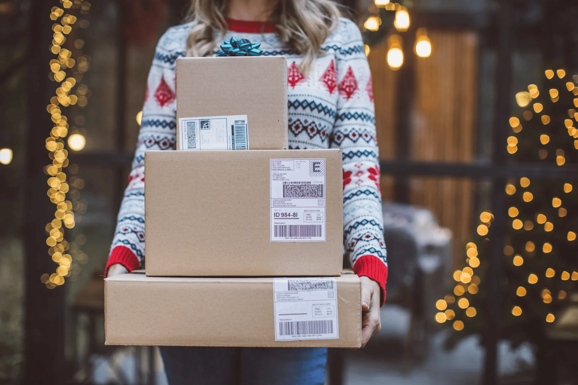 person in christmas jumper holding parcels