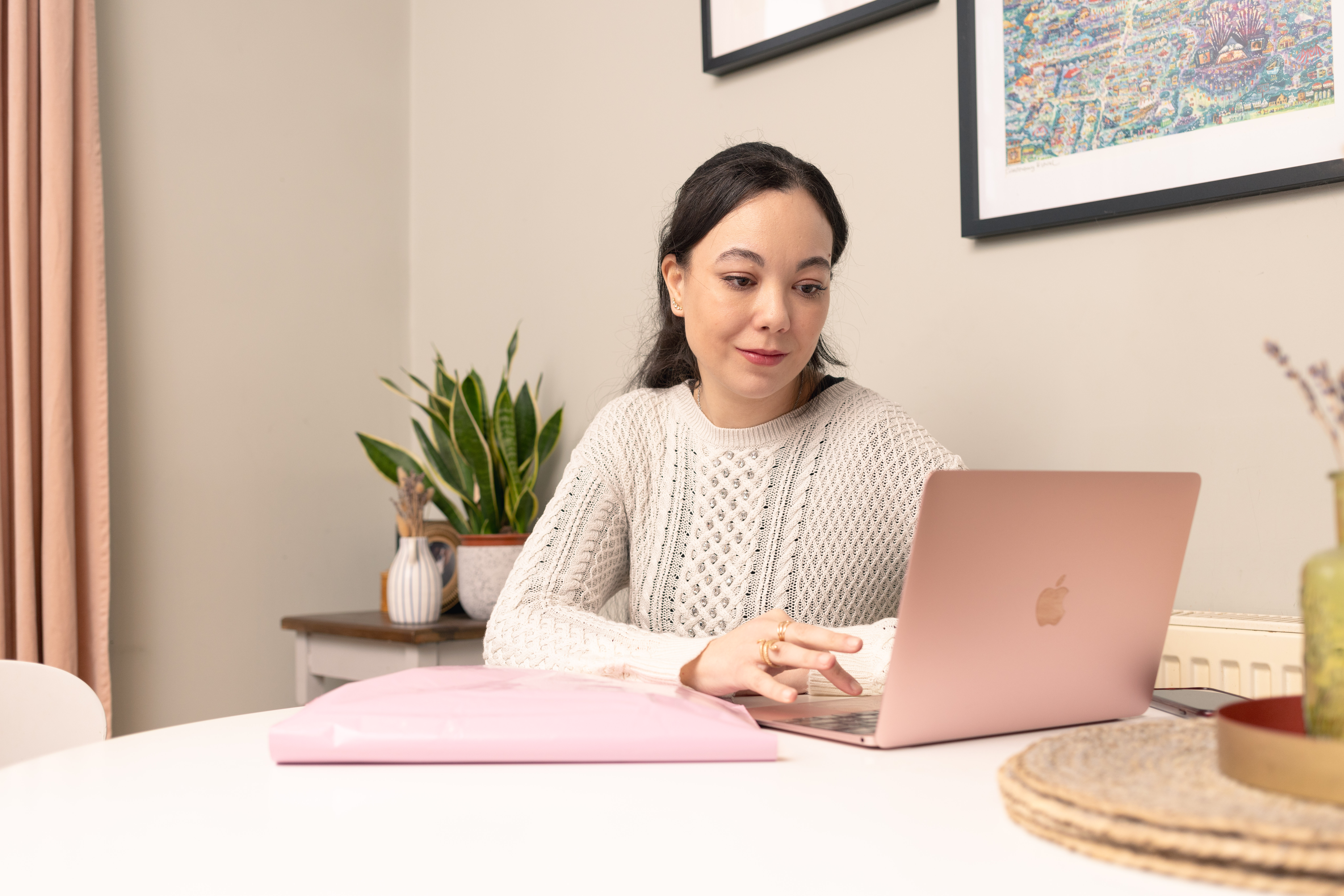 Woman checking her pink laptop.