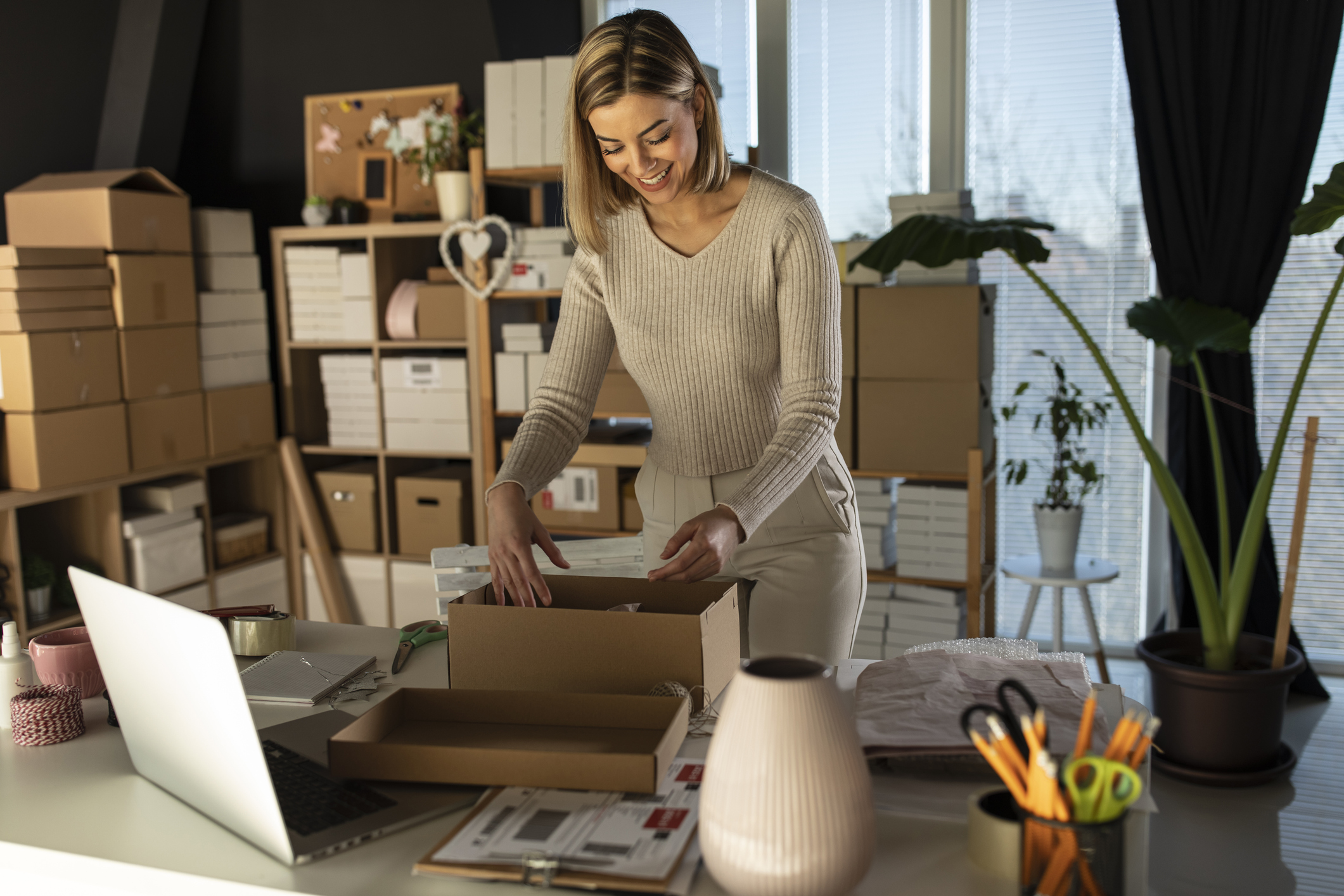 Woman packing parcel at home for delivery