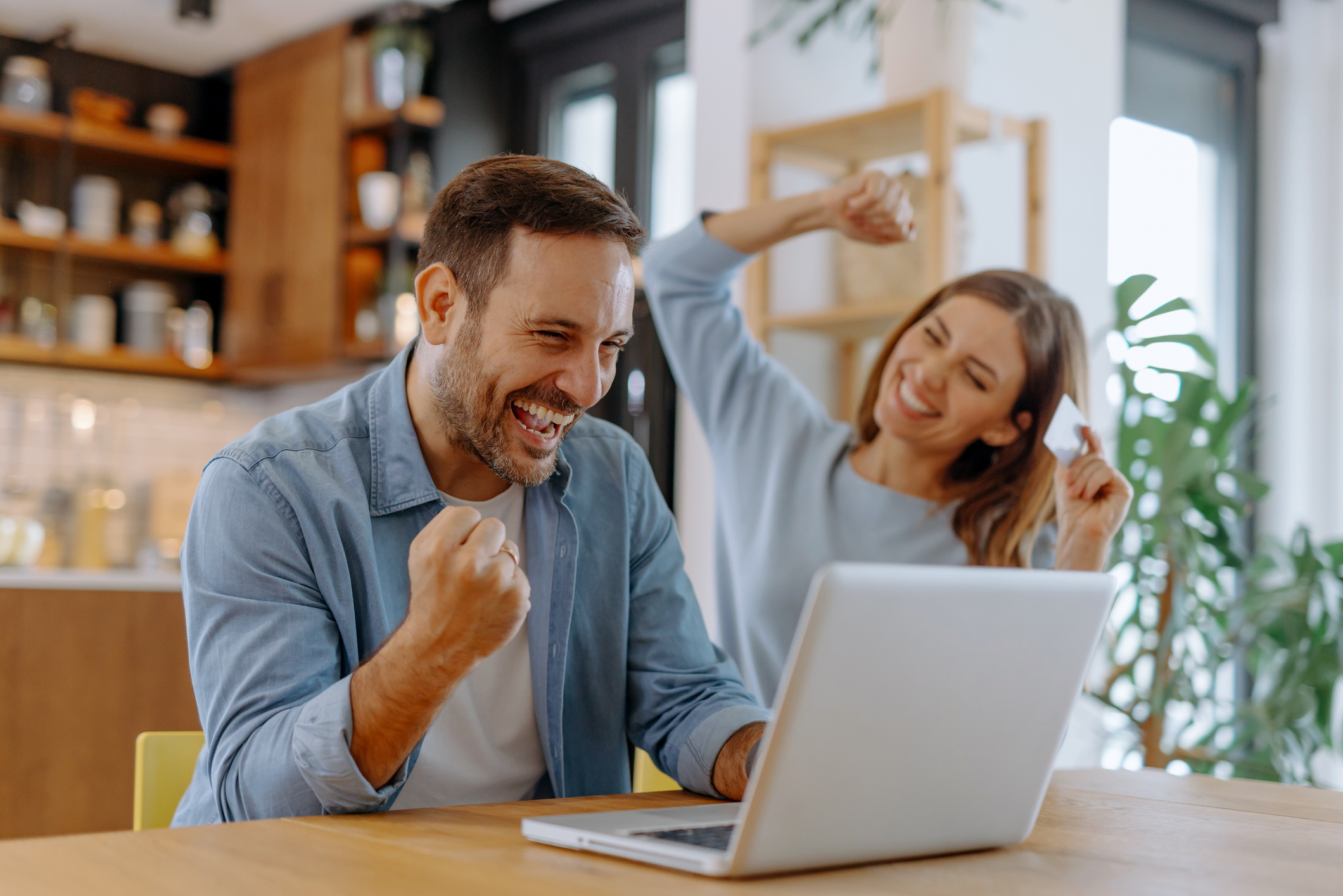 couple celebrate online deal at their laptop