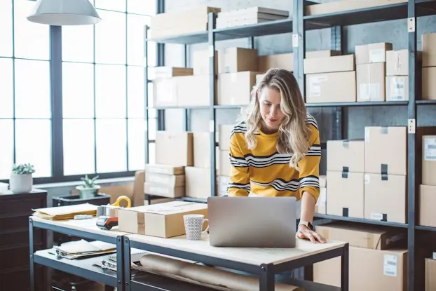 Woman in yellow top in warehouse of boxes