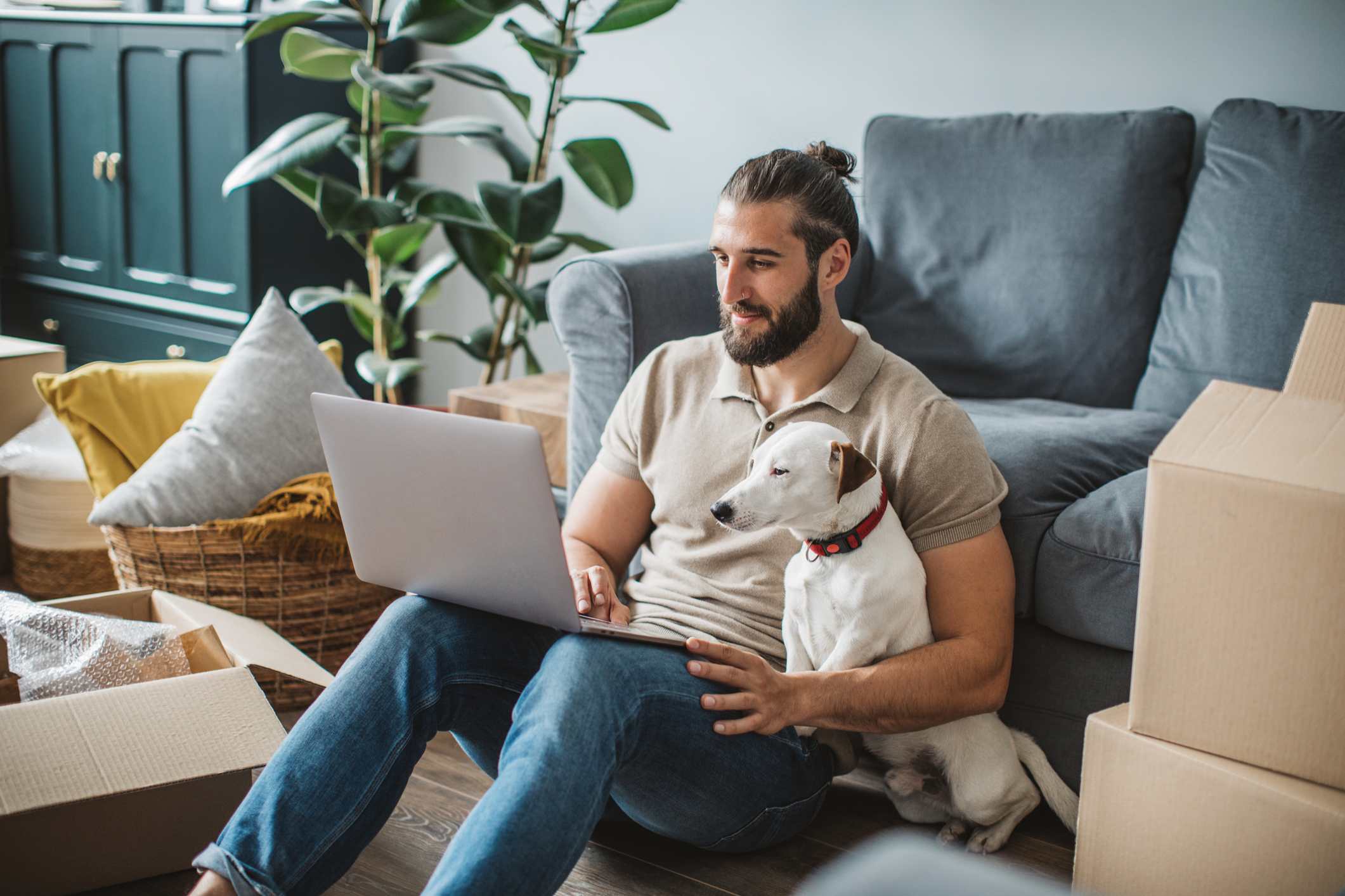 Man using laptop with parcels in background