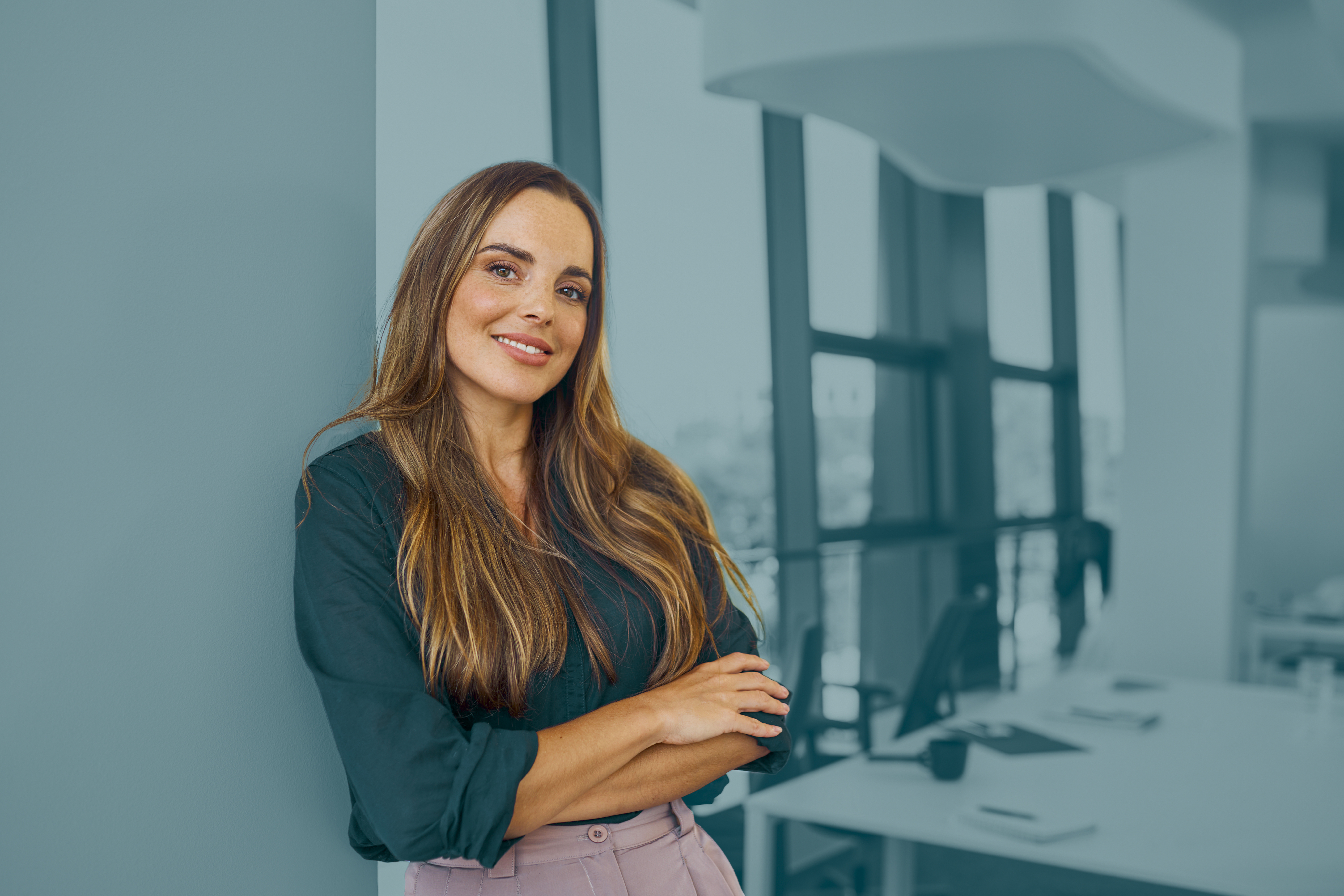 Woman leaning against wall in meeting room.