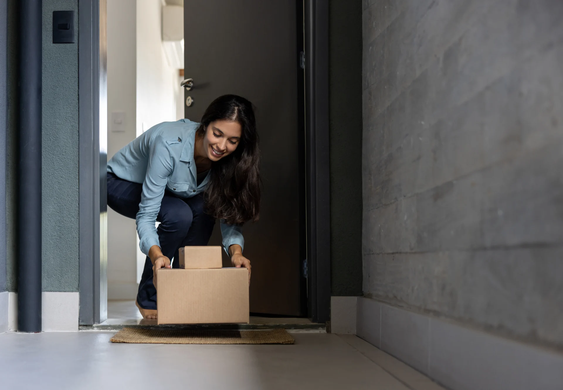 woman picking up parcels at door