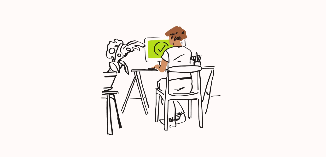 Person types at desk. Large checkmark on computer screen.