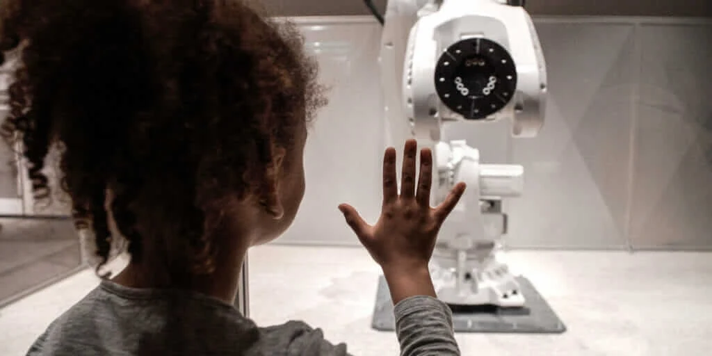 ロンドンのデザイン・ミュージアムで Mimus のブースに近づく子供