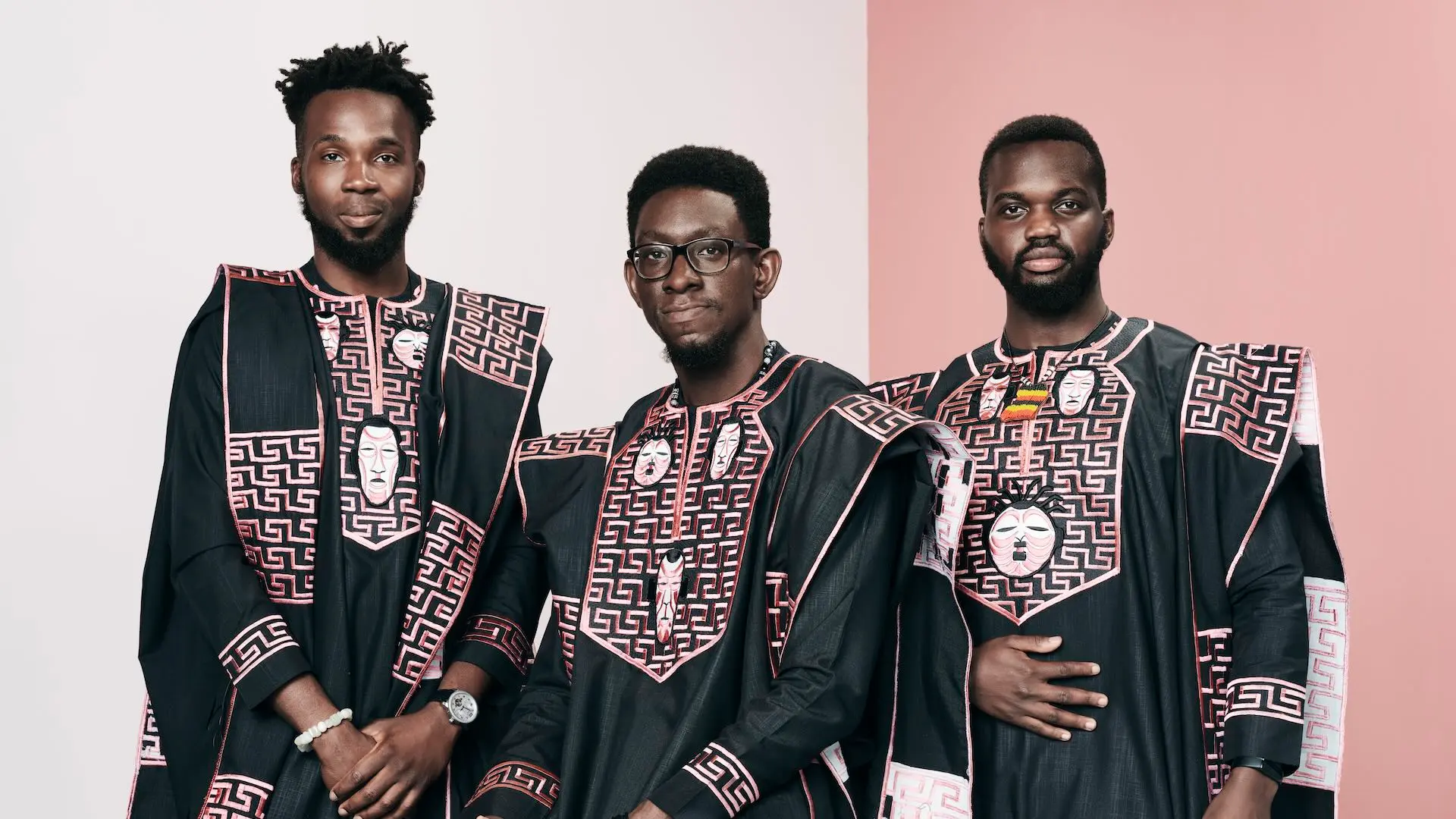 Olufikayo „Ziki“ Adeola, Toluwalakin Olowofoyeku und Hamid Ibrahim von Kugali Media posieren in afrikanisch inspirierten formellen Gewändern.