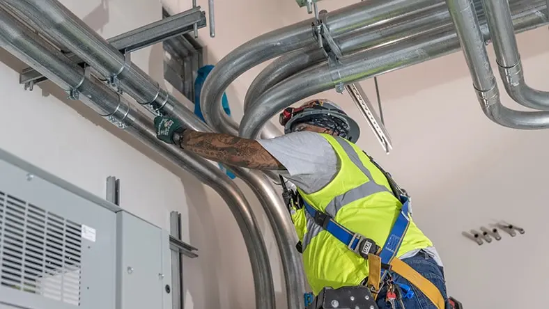 An engineer adjusts a building ventilation system.