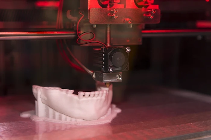 A 3D printer printing a human jaw replica