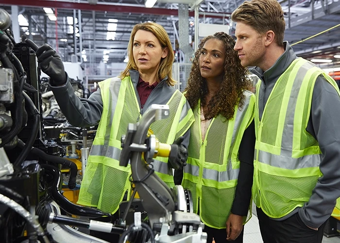 Drei Fabrikarbeiter inspizieren Maschinen.