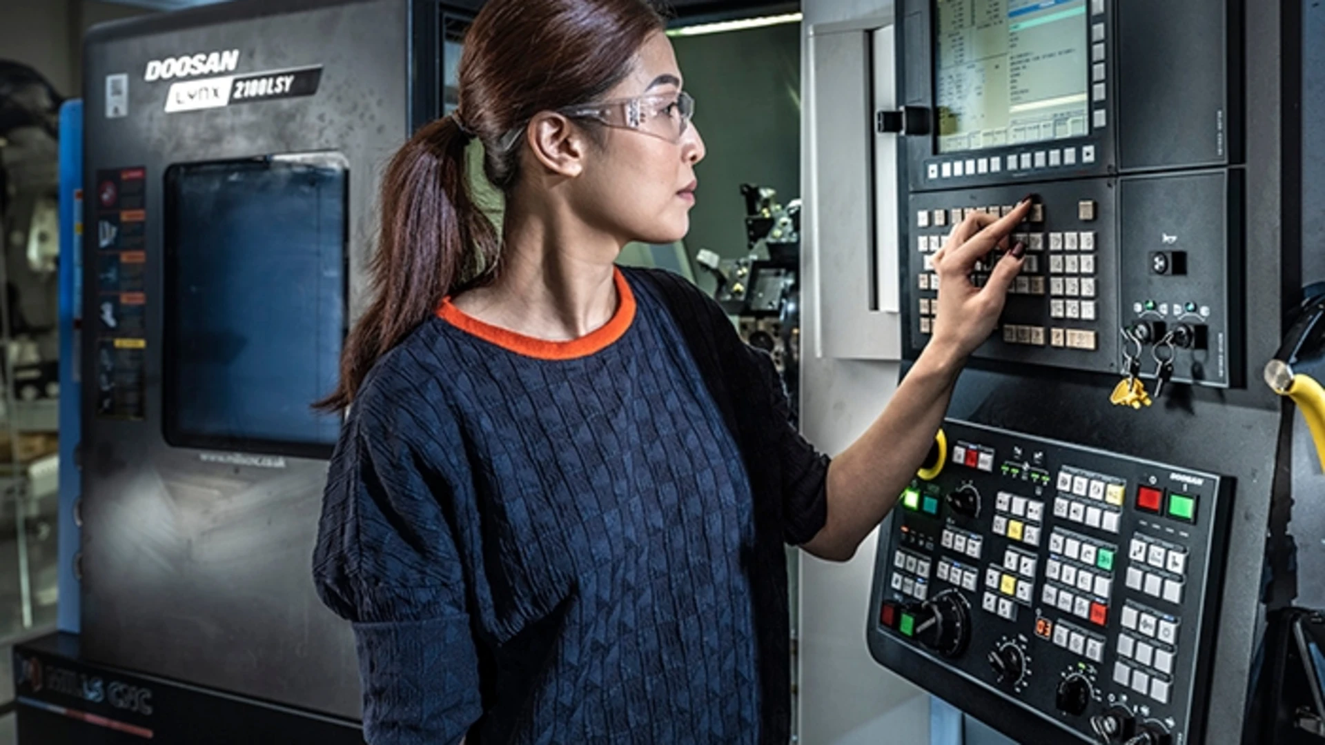 a worker checks manufacturing machinery