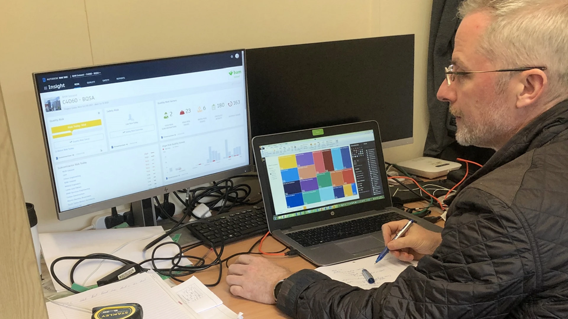 Simon Tritschler of BAM Ireland reviews project data on a computer monitor.