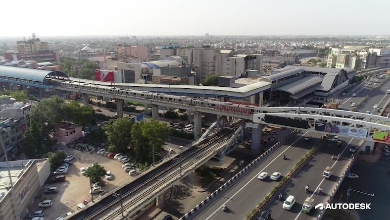 A still from a video shows a rail system over a roadway as part of a joint venture ecosystem between Delhi Metro Rail Corporation Limited and India.
