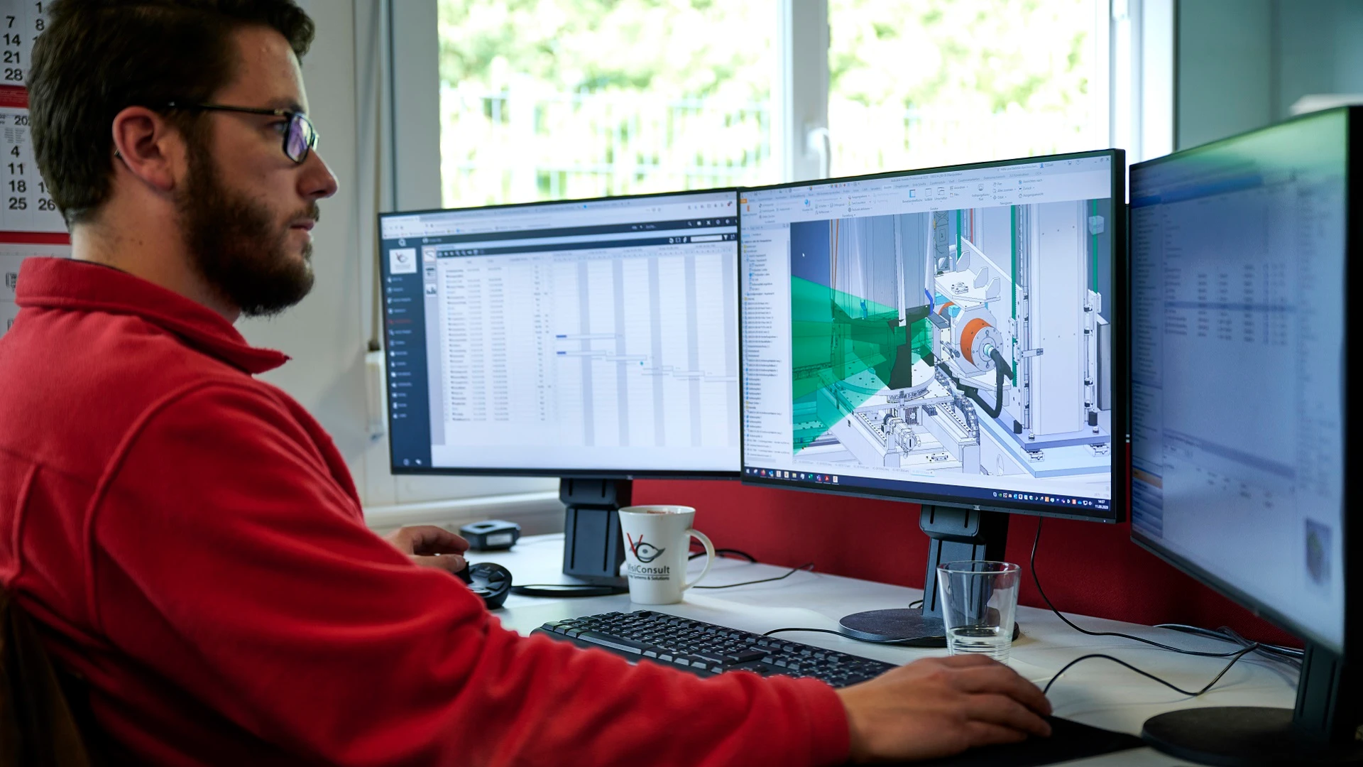 A man works on the design of an X-ray unit using 3 computer screens that show a 3D model and data.
