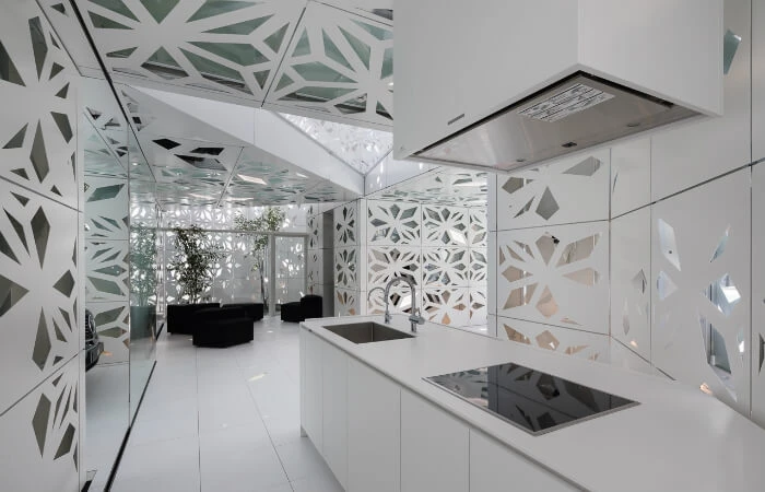 Die Küche im EQ-Haus: Ausschnitte in den Wandpaneelen sorgen für einen optimalen Lichteinfall von außen und streuen innen Kunstlicht. 