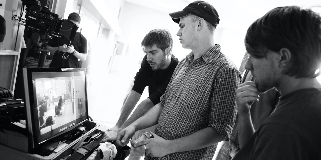 People working on a film in front of a computer