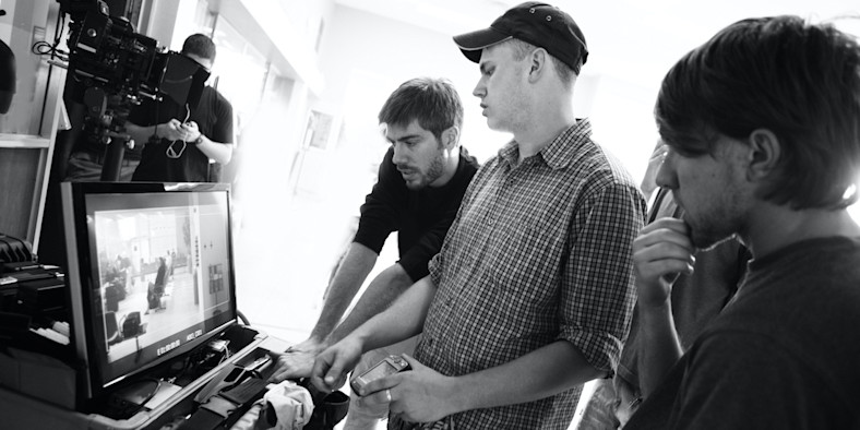 People working on a film in front of a computer