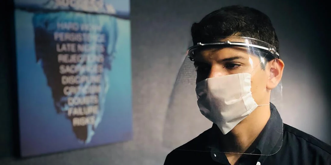 A man wears a Spacelab 3D-printed PPE mask and a surgical mask.