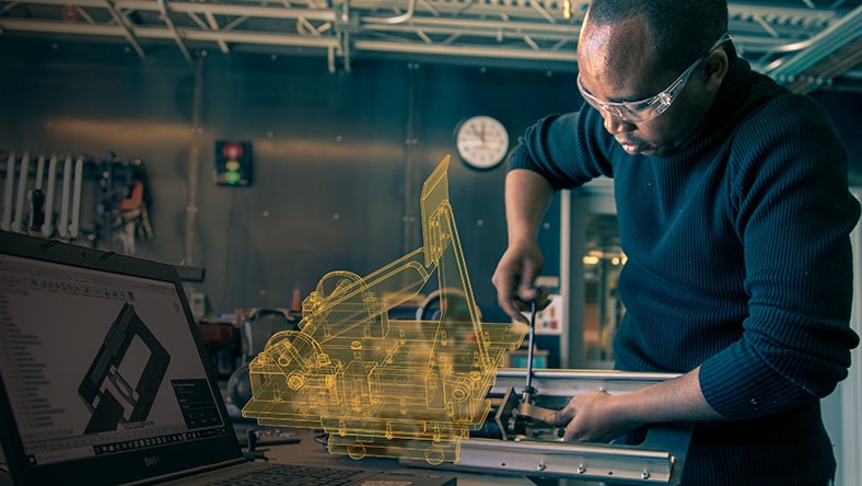 Man working on physical product while consulting his Autodesk CAD software.