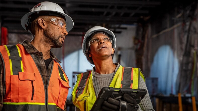Employees using BIM for construction on a tablet