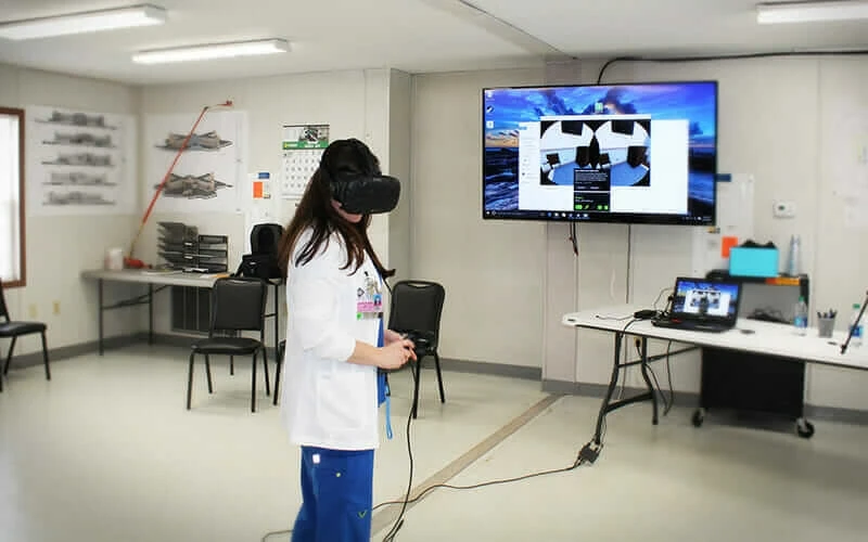 A female medical professional wears a VR headset in a health care setting.