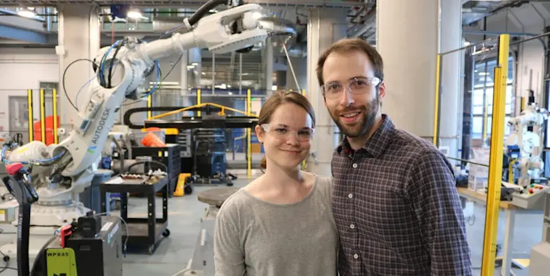 Betsy and Mike Jasper of Tarkka pose in front of machines at an Autodesk Technology Center