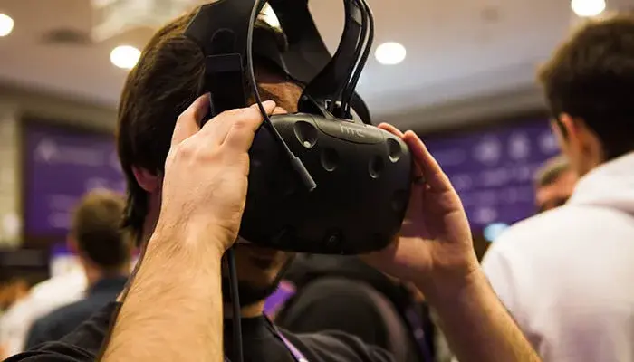 A man wears HTC VR goggles.